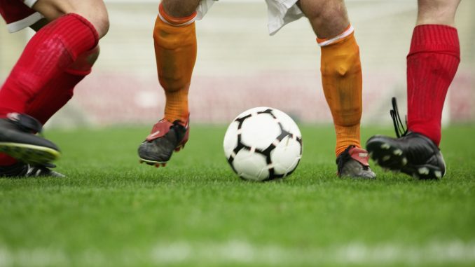 Soccer Player Dribbling Between Defenders